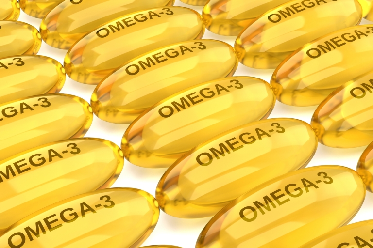 A close-up image of multiple omega-3 supplement capsules.