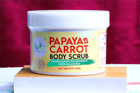 A container of avia papaya & carrot body scrub positioned in front of a red background.